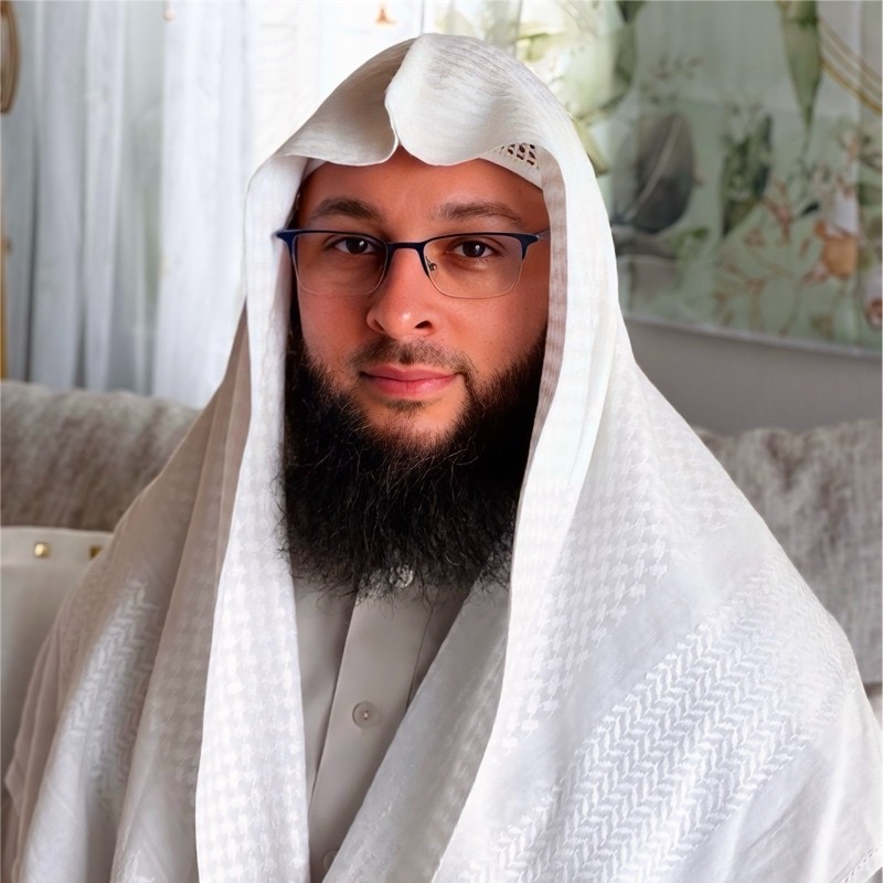 Naasir Bush at home, wearing glasses and a white head covering